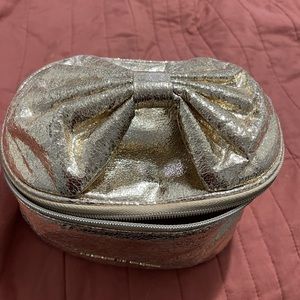 Victoria’s Secret Gold Makeup bag with bow handle detail.